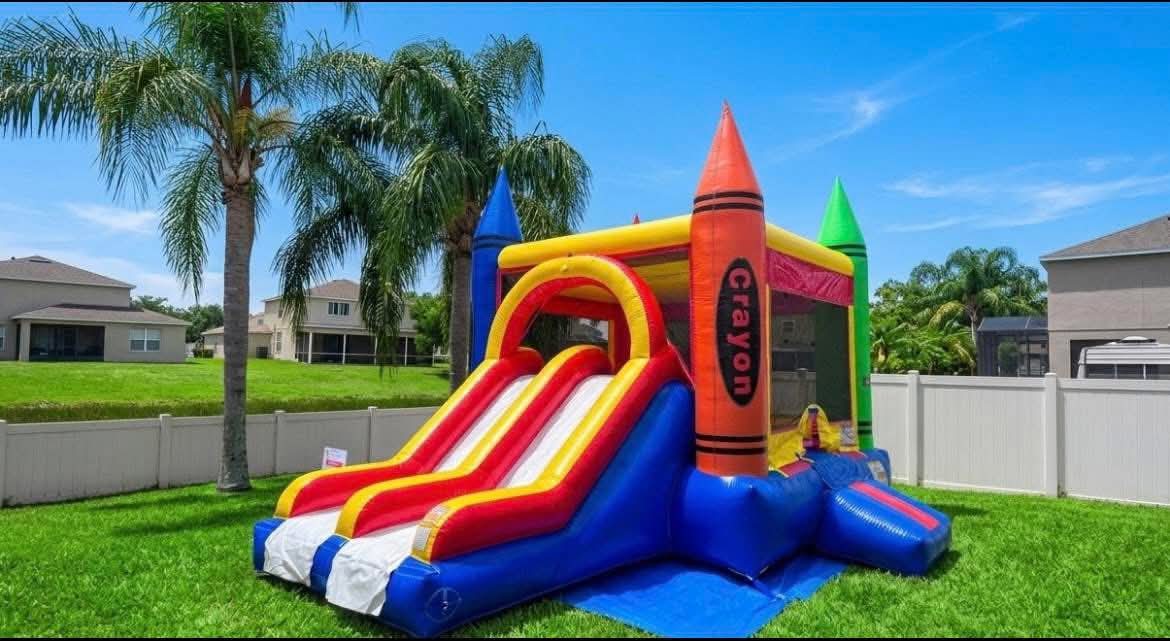 Crayon bounce house with slide in a Florida backyard